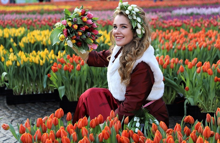 Woman selling flowers at a flower market in Amsterdam (photo by Andy Bellm from Pixabay)