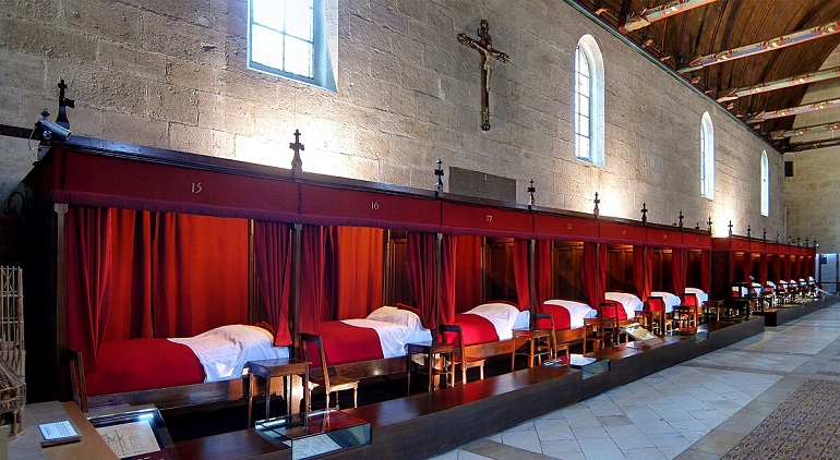 Row of beds in the Grande Salle des Pôvres, Hospices de Beaune (photo by Velvet - CC BY-SA 3.0)