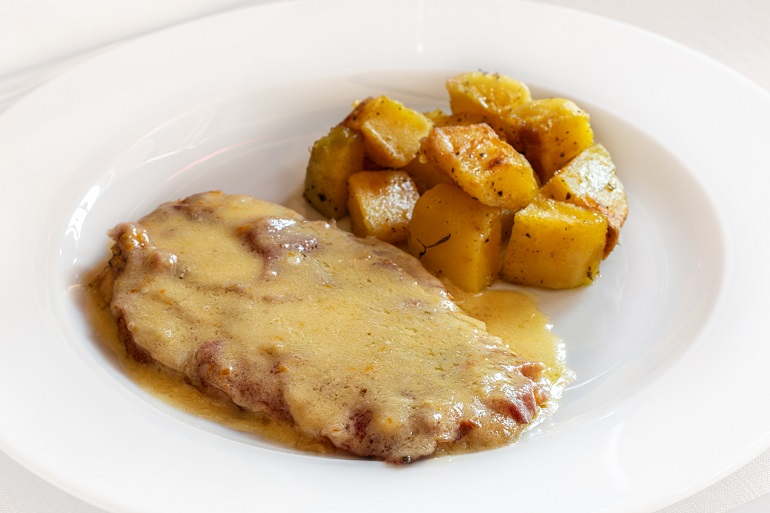 Cotoletta alla bolognese with baked potato, traditional dish of Bologna (© Olga Mazyarkina | Dreamstime.com)