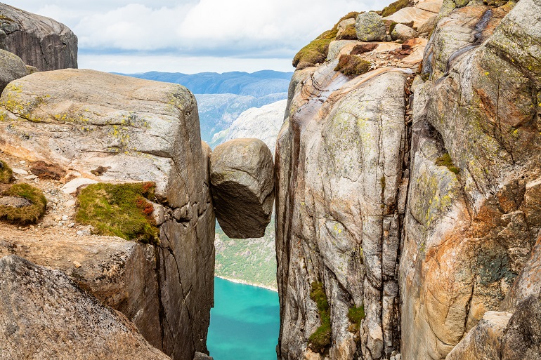 Kjeragbolten, the stone stuck between two rocks with fjord in the background, Lysefjord (© Vadim Nefedov | Dreamstime.com)