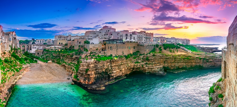 Sunset at Cala Paura gulf with Bastione di Santo Stefano and Lama Monachile beach, Polignano a Mare (© Blunker | Dreamstime.com)